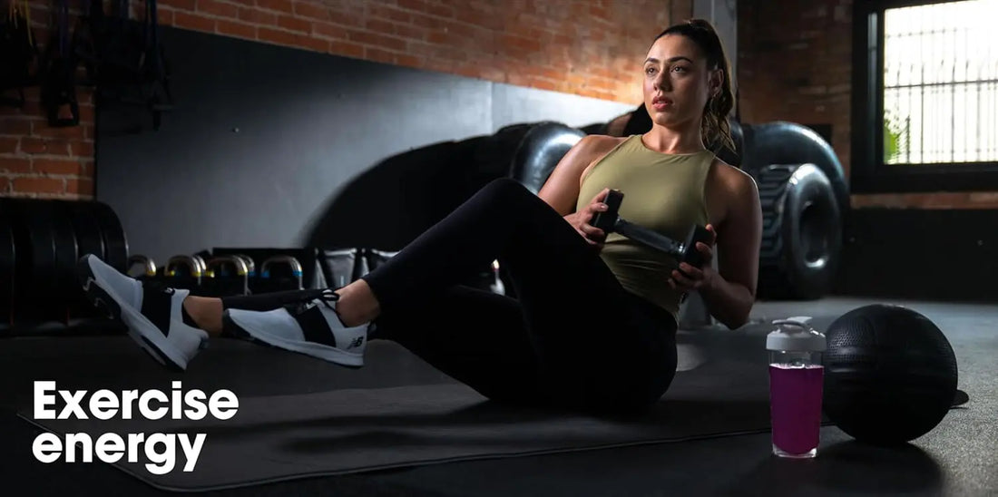 Mujer entrenando con pesas en gimnasio, suplemento energético en botella